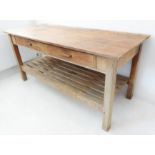 An early 20th century pine table: the overhanging top above two frieze drawers, raised on square