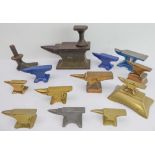 A series of miniature cast brass anvils, together with painted examples, and a miniature iron