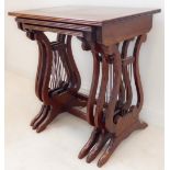A nest of three mahogany and crossbanded occasional tables raised on lyre style ends (51cm wide x