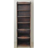 An dark oak open bookcase of slim proportions: three-quarter galleried top above seven bow-fronted