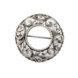 A circular silver brooch pierced with foliate scrolls (boxed)