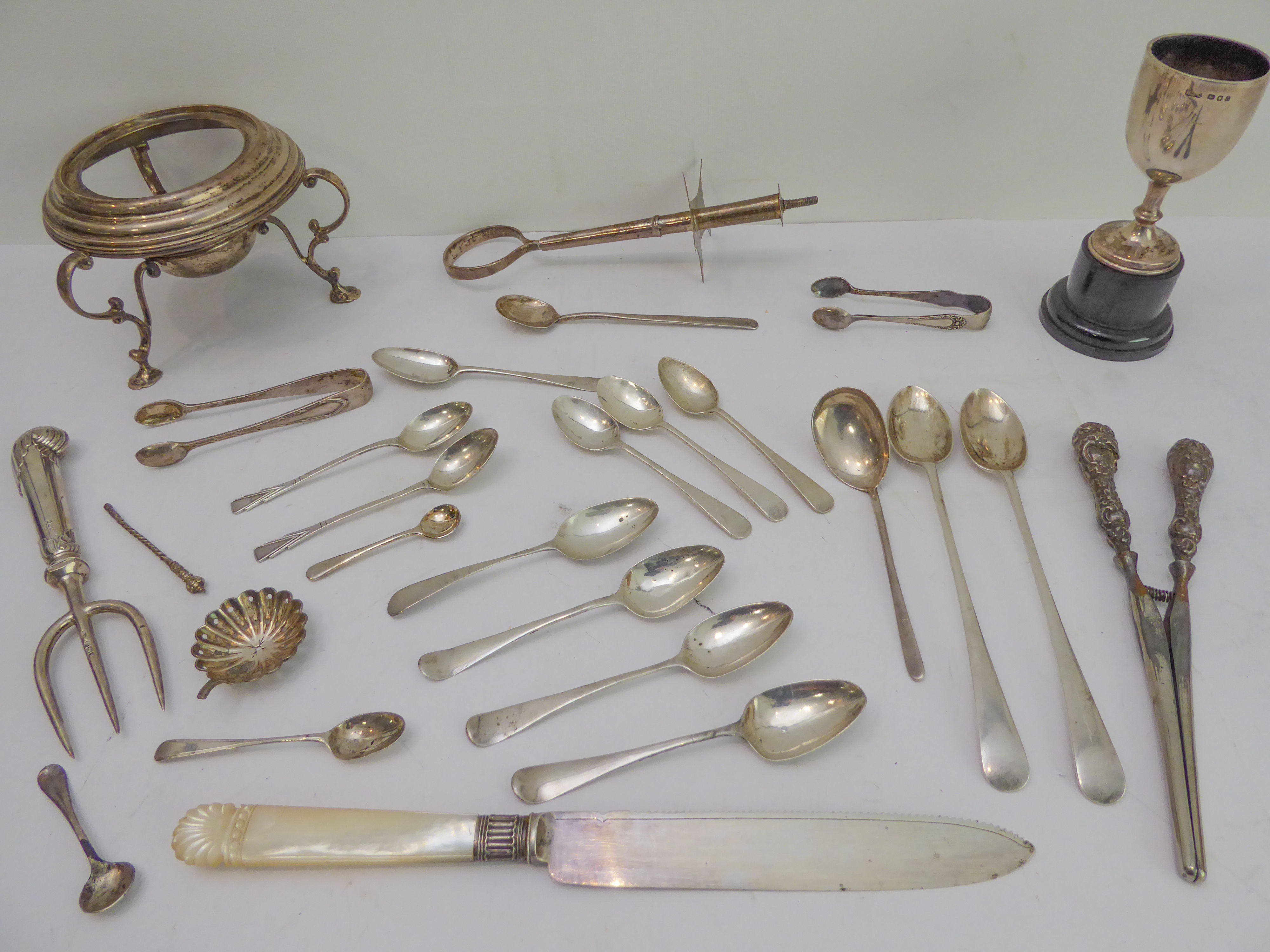 A selection of silver to include: teaspoons, long spoons and sugar tongs; a mother of pearl