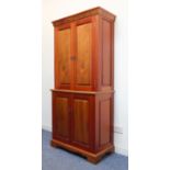 A modern walnut side cabinet of slim proportions; the cornice with elliptical decoration above