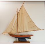 A model pond yacht on a plinth base