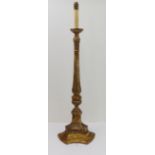 An early 20th century carved wood floor-standing lamp: turned fluted stem above an acanthus bulb and