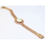 A 9-carat rose gold double link chain bracelet centrally set with an oval opal: the chain links