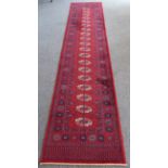 A red ground machine-made Persian-style runner with gul pattern (365 x 69 cm)