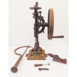 A large and heavy pillar drill: hand operated with a wooden handle on a wheel mechanism, together