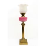 A 19th century brass and opaline glass oil lamp: the white glass crimped-edge top decorated in