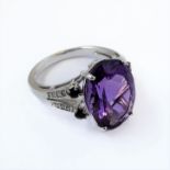 A 9 carat white gold ring set with amethysts and with diamond chips to the shoulders, size M/O