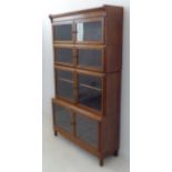 An early 20th century oak bookcase with hinged glazed doors: four-stack with varying sized glass