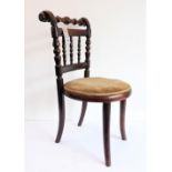 An early 20th century stained wood child's chair with circular seat: spindle back above bent wood