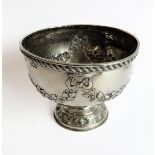 A heavy hallmarked silver pedestal bowl: decorated in repoussé style with bows and swags;