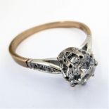 A 9 carat gold ring set with a central white stone and with six small white stones to the shoulders,