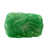 A Jadeite Chinese pendant (20th century): each side carved in high relief with an open winged bird