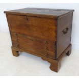 A George III period mahogany chest: the hinged top opening to reveal a left-hand candle