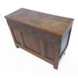 An antique oak chest: the hinged cleated one plank top above 17th century style carving and an