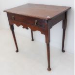 An 18th century oak side table: the moulded top above a single full-width drawer with two Dutch