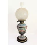 A late 19th century ceramic oil lamp: spherical, etched clear-glass shade; the circular tapering