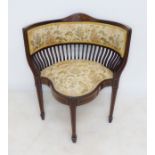 An Edwardian mahogany and upholstered bergère chair: the back with foliate style marquetry above