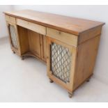 An early 19th century style pine sideboard; the slightly overhanging top above central drawer