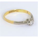 A small gold ring set with a small single solitaire diamond: the inside of the ring marked '18CT &