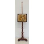 A mid-19th century mahogany pole-screen: floral needlework screen; raised on triform base with squat