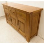 15 A fine solid heavy oak sideboard: the cleated overhanging top above an arrangement of three