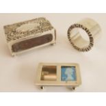 A silver group of three: a hallmarked silver matchbox holder, repoussé decoration and with vacant