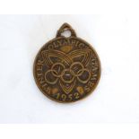 A 1952 Winter Olympic Games medallion with suspension loop (3.75 cm in diameter). (Some wear,