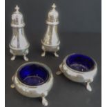 A four-piece hallmarked silver cruet set by Goldsmiths & Silversmiths Co., London: two circular