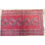 A mid-20th century fragment of a North Afghan runner: red ground with five guls (132 x 85 cm).