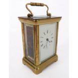 An English gilt-brass and glass-sided carriage clock timepiece: white enamel dial with Roman