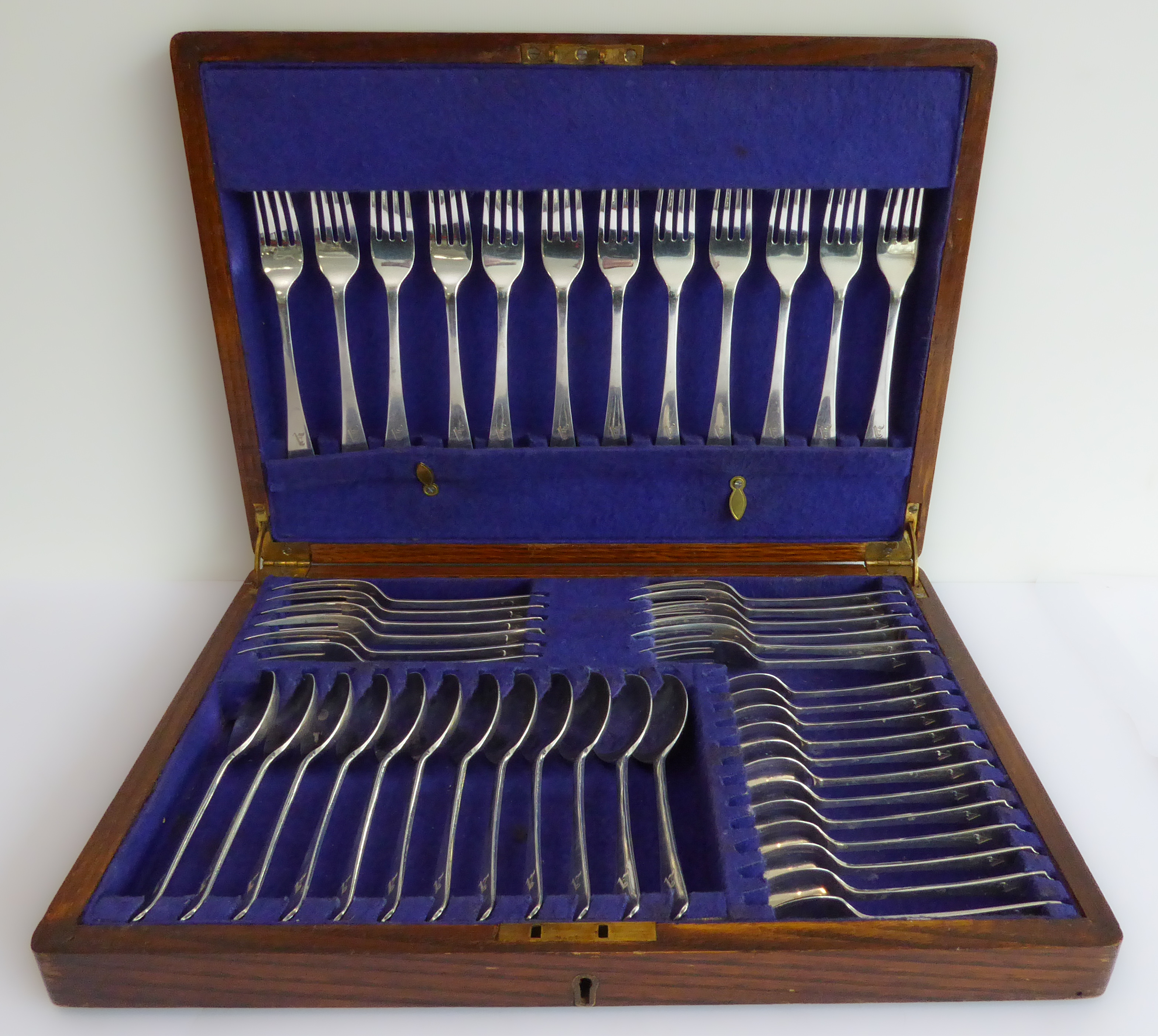 An oak-cased early 20th century 12-place hallmarked silver flatware set, each piece monogrammed A,