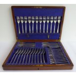 An oak-cased early 20th century 12-place hallmarked silver flatware set, each piece monogrammed A,