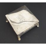 A hallmarked silver cedar-lined cigarette box: square form and raised on four animal's paw style