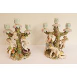 A pair of late 19th century German porcelain three-light figural candelabra: 1. a boy treading