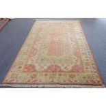 A large contemporary Turkish melas carpet: a central salmon pink rectangular panel of stylised