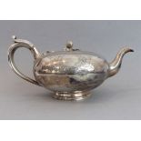 A large 19th century silver-plated teapot of squat bun form: the finial as a bud and leaves above
