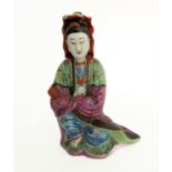 An 18th/19th century Chinese pottery model of a seated Guanyin: green and purple long flowing