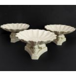 A set of three late 19th to early 20th century glazed pedestal bowls: shell-form bowls supported