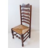An early 19th century ash and oak ladderback chair with mahogany verticals and rush seat: turned