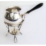 An Edwardian silver brandy warmer on stand with burner. Pot belly form with ebony handle. Hallmarked