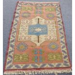 A modern Turkish melas rug: coral ground with large ivory central medallion (condition generally