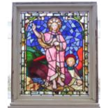 A later framed stained glass window panel: the standing Christ figure with halo and dressed in
