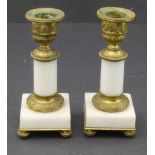 A pair of 19th century French gilt-metal table candlesticks of classical form and with marble