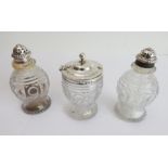 Three matching early 19th century cut-glass and silver-lidded cruets comprising a salt, a pepper and