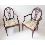 Two similar late 18th century mahogany open armchairs: each with oval back carved with swags to