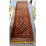 An Afghan runner of slim proportions: terracotta ground with six lozenges, three borders and