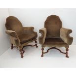 A pair of upholstered walnut armchairs in late 17th style: shaped scrolling arms, Braganza-style
